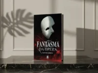 Livro 'O Fantasma da Ópera' com máscara branca sobre pedestal de mármore preto sob sombra de folha.