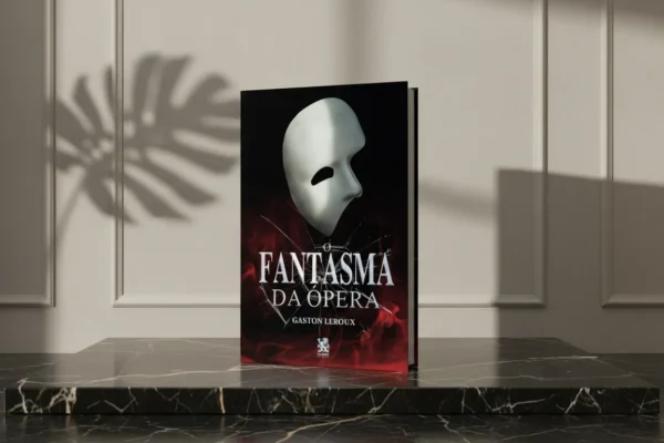 Livro 'O Fantasma da Ópera' com máscara branca sobre pedestal de mármore preto sob sombra de folha.