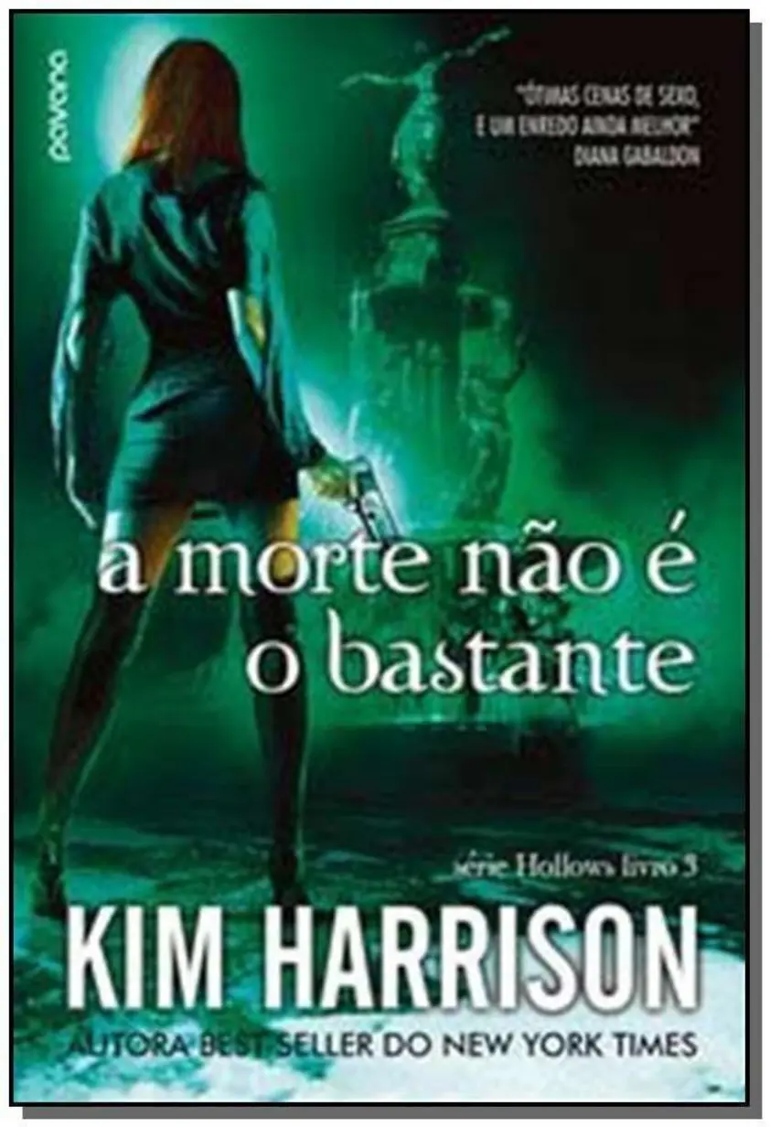 Livro 'A morte não é o bastante' aberto em uma mesa de cabeceira com uma xícara de chá.