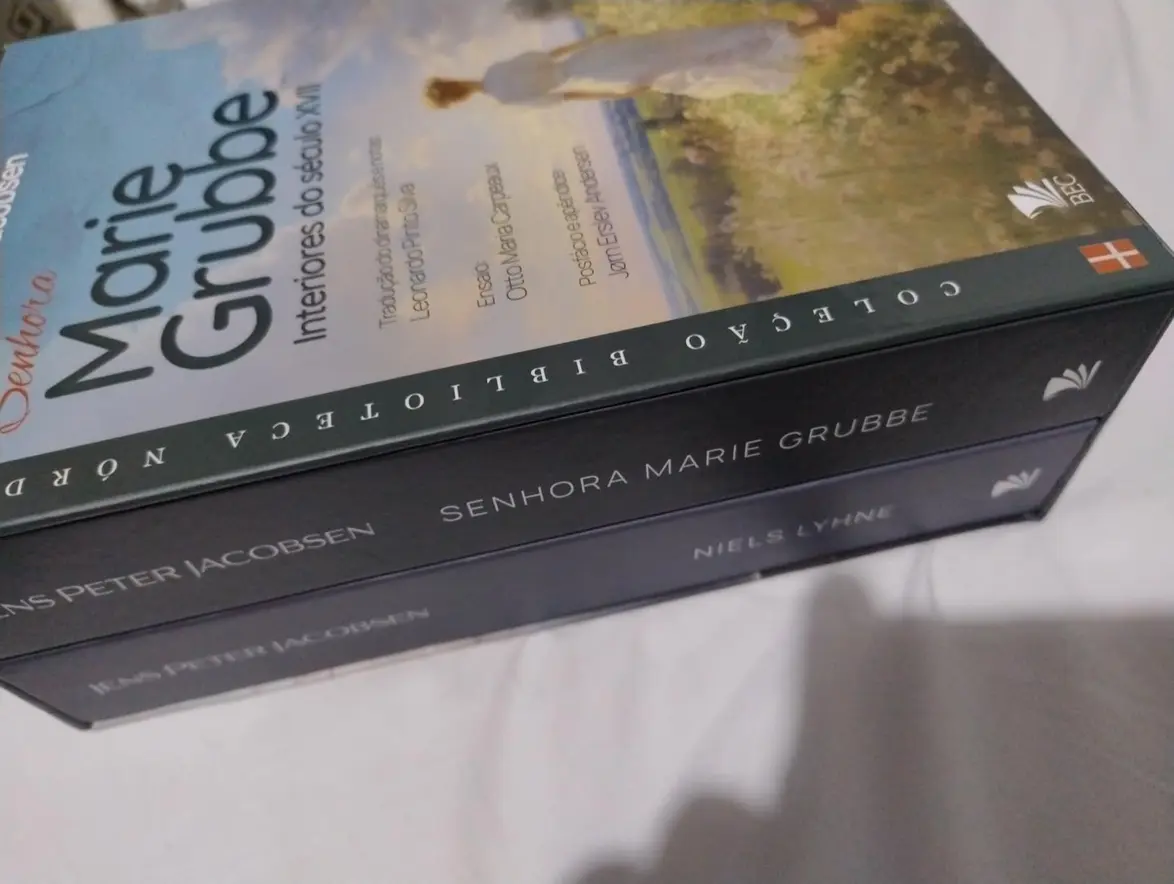 Livro do Box Romances Jens Peter Jacobsen aberto em uma mesa de madeira.