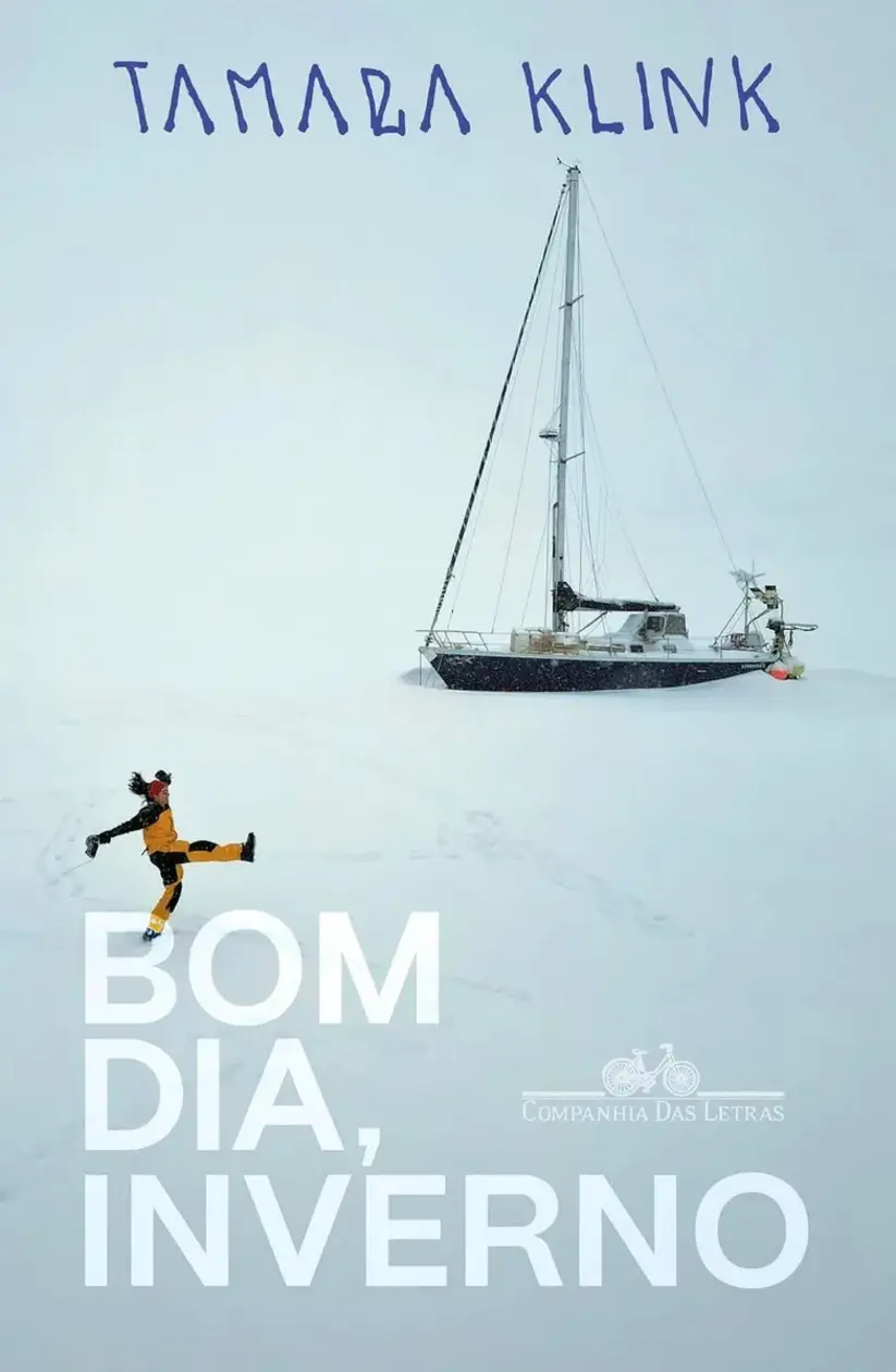 Livro Bom dia, inverno aberto sobre uma mesa de madeira com uma xícara de chá
