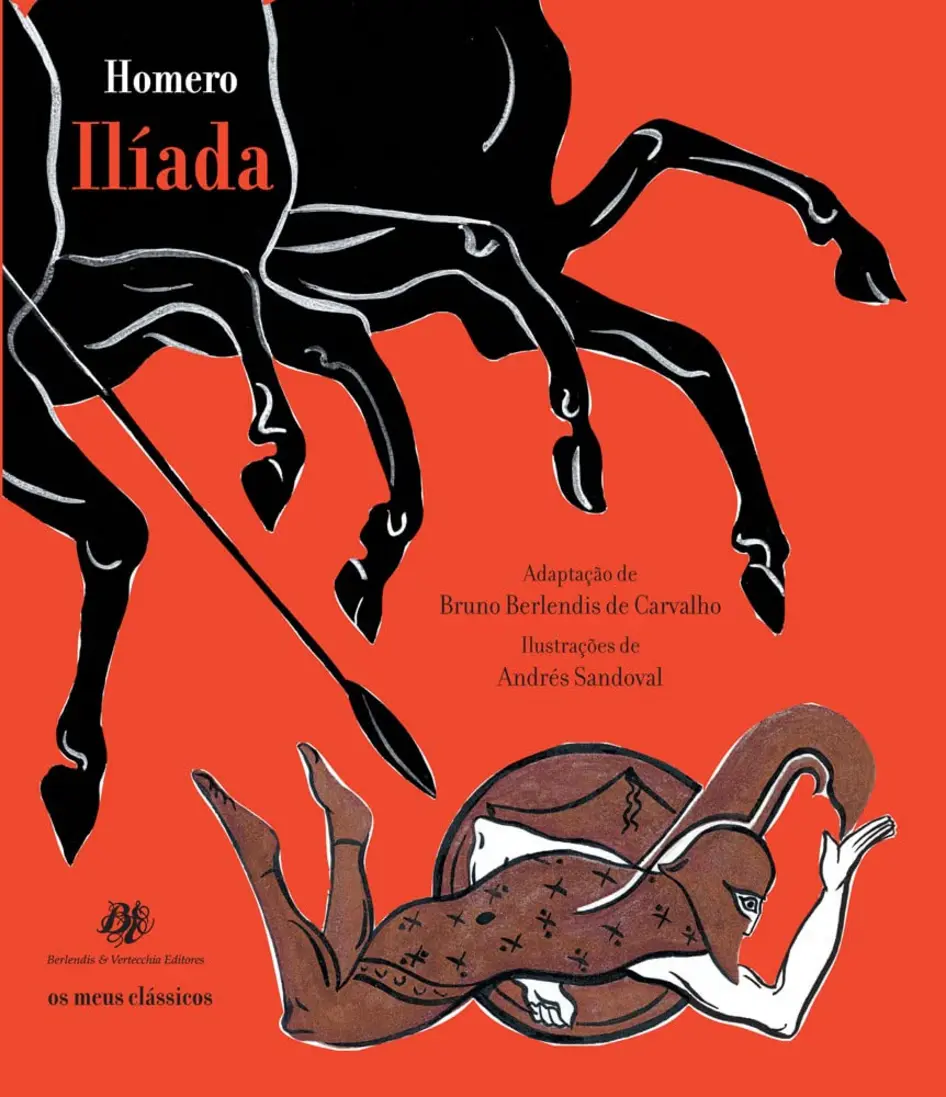 Livro Ilíada em brochura sobre uma mesa de madeira, em um ambiente de leitura.