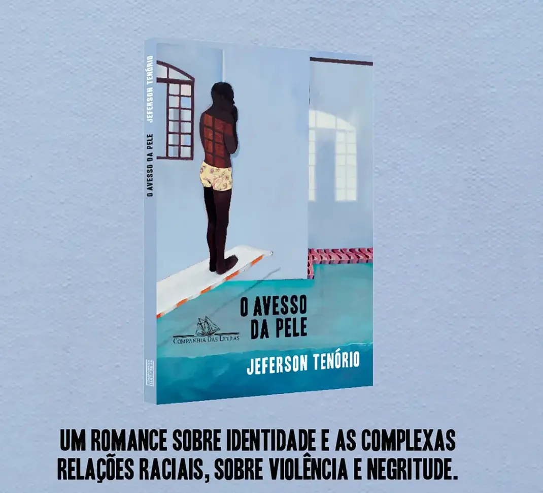 Livro 'O Avesso da Pele' aberto sobre uma mesa de madeira, com páginas visíveis.