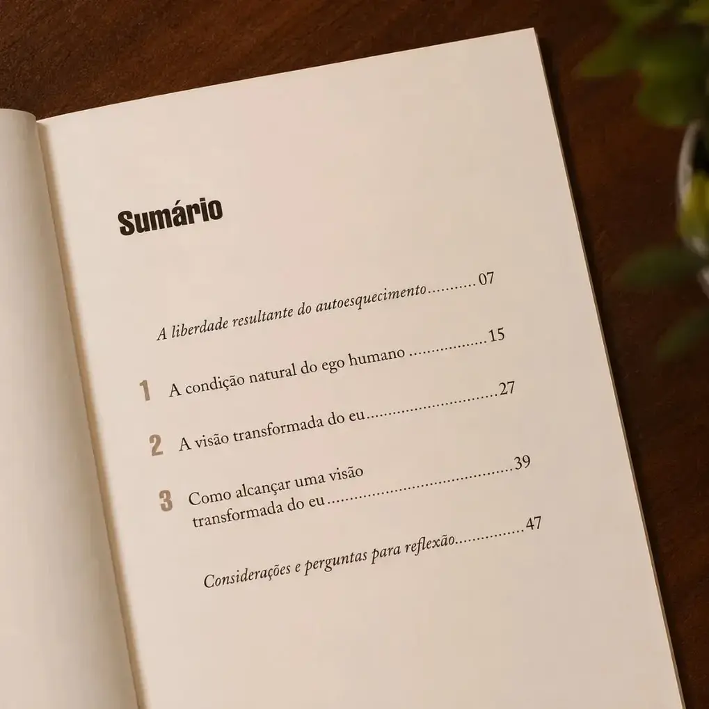Livro Ego Transformado aberto sendo lido, com as páginas visíveis.