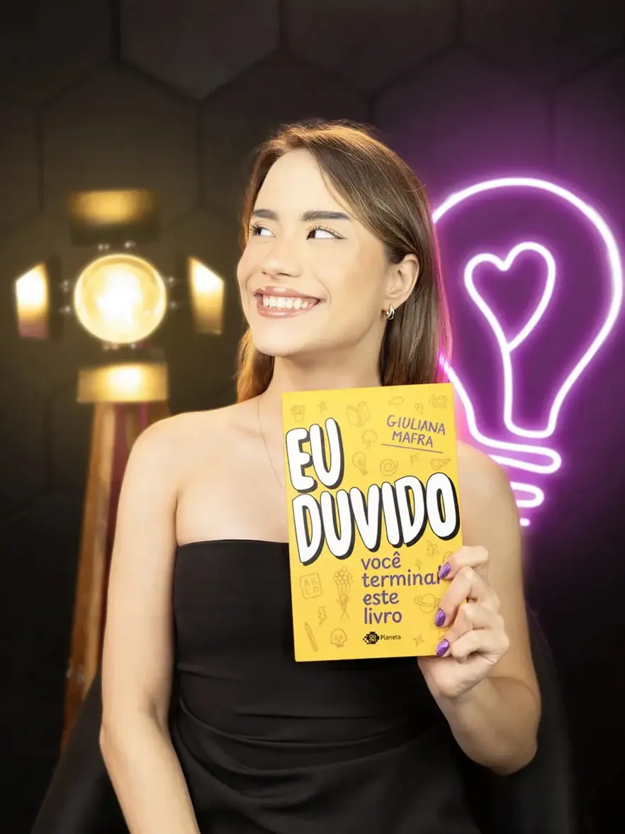 Pessoa interagindo com o livro Eu duvido você terminar este livro, escrevendo ou marcando páginas