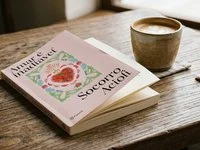 Livro de capa lisa aberto sobre uma mesa de madeira ao lado de uma xícara de café, em luz suave de fim de tarde